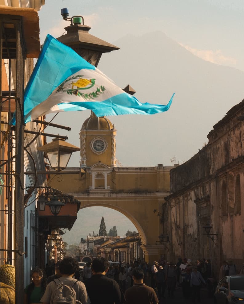 Guatemalan flag flying over Antigua's Santa Catalina Arch
